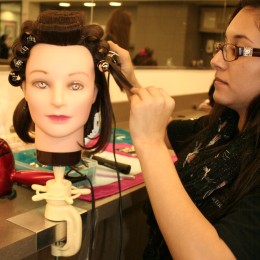Cynthia Velazquez prepares for the March “Art of Hair” show on her mannequin, which was held in the Hayden Memorial Library.