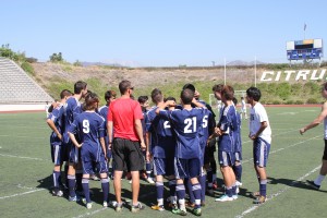 The Owls men's soccer team has a team huddle before the match.