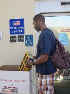 Sean Horace, 23, kinesiology major, stops by the Veterans Center to donate a toy truck set into the Toys for Tots collection bin. (Sarah Cha/ Citrus College Clarion)
