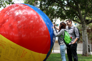 Biology major Michael Ramage (right) and Dental program student jazmin Chau (left) add their message to the giant free speech ball on April 25 in the Campus Center Mall. The ball was brought out by the unofficial Citrus College Turing Point USA chapter. 