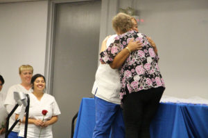 Emma Collins hugs professor Wong while the rest of the nurses wait in line to receive their nursing pins at the Vocational Nurses Pinning ceremony Aug. 25 in the Campus Center Mall.